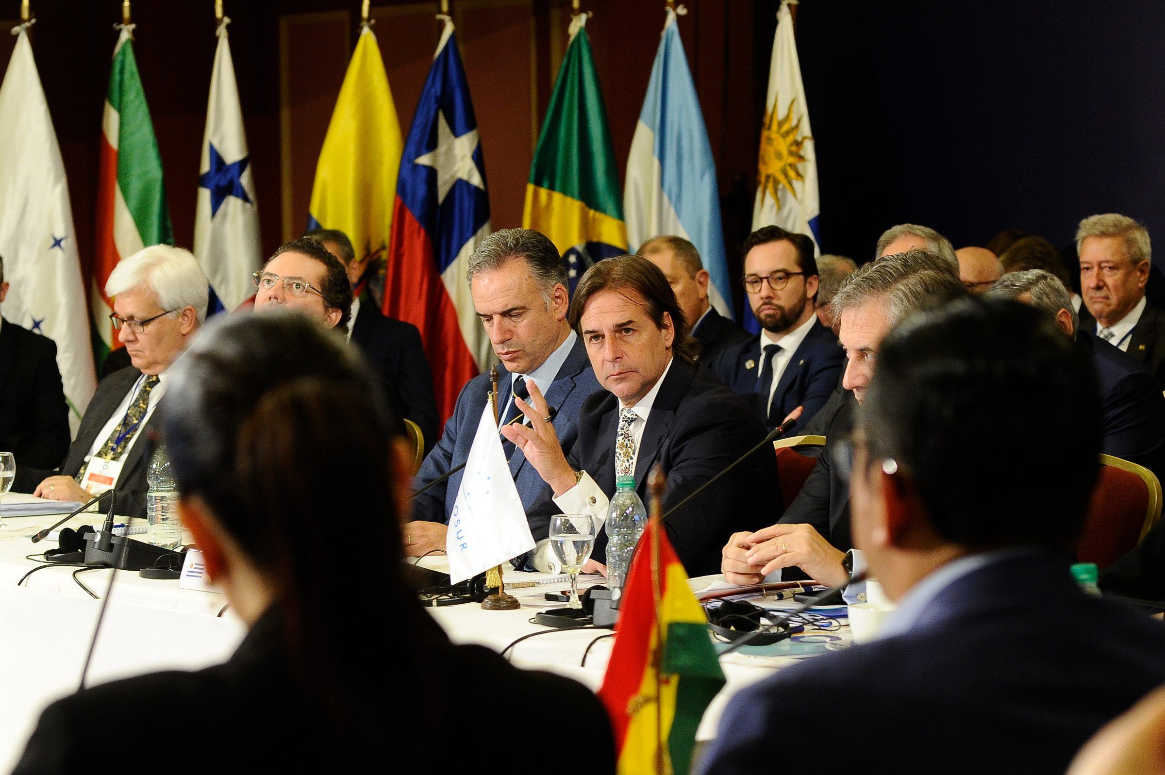 Mesa de la cumbre con las banderas de los países del Mercosur y de los Estados asociados al fondo.