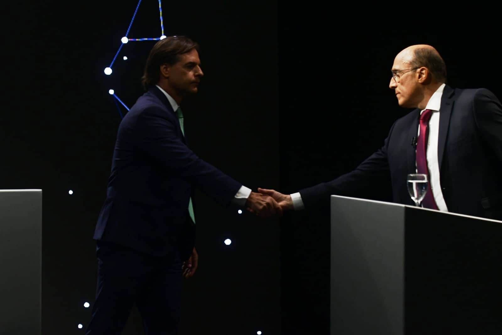 Saludo final entre los dos candidatos, cada uno junto a su atril, sobre el fondo de constelaciones del set del debate presidencial