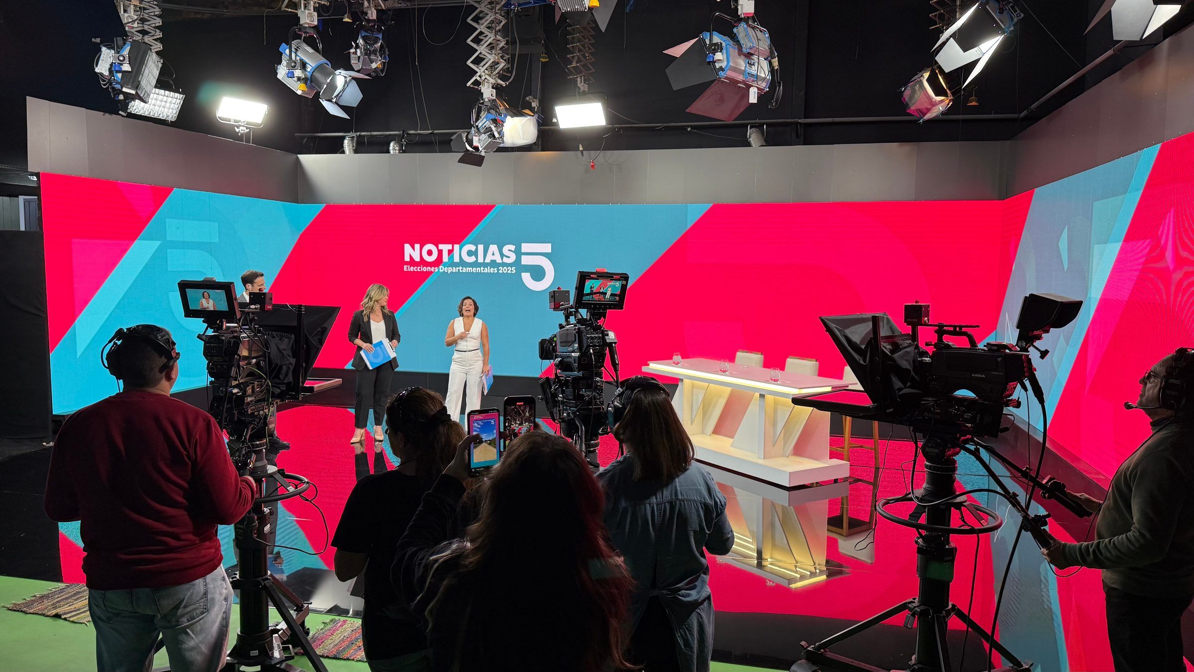 Set de Noticias 5 durante la cobertura electoral, con cámaras, presentadores y equipo de piso en el estudio.