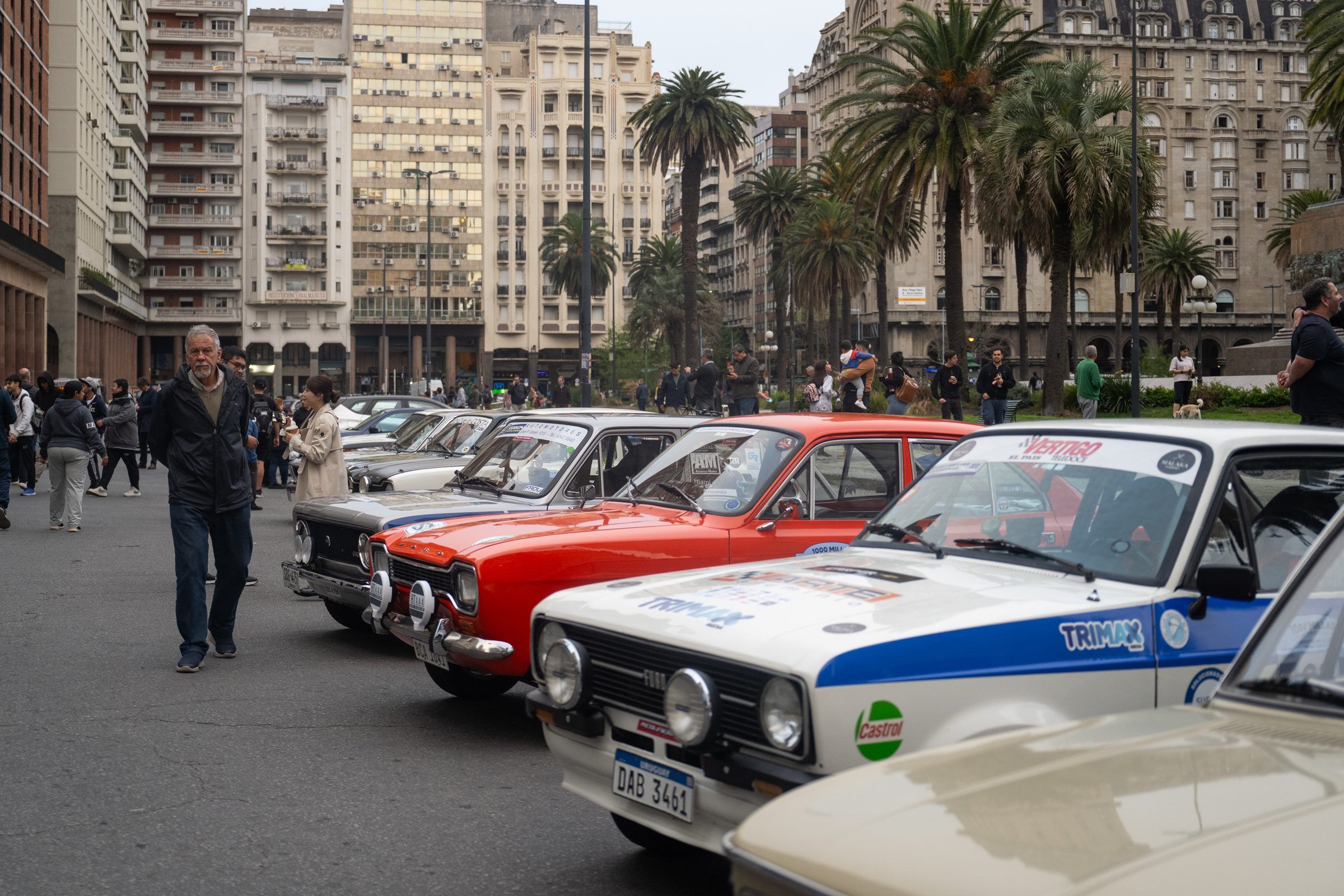 Fila de autos de rally clásicos alineados en la calle durante la largada simbólica