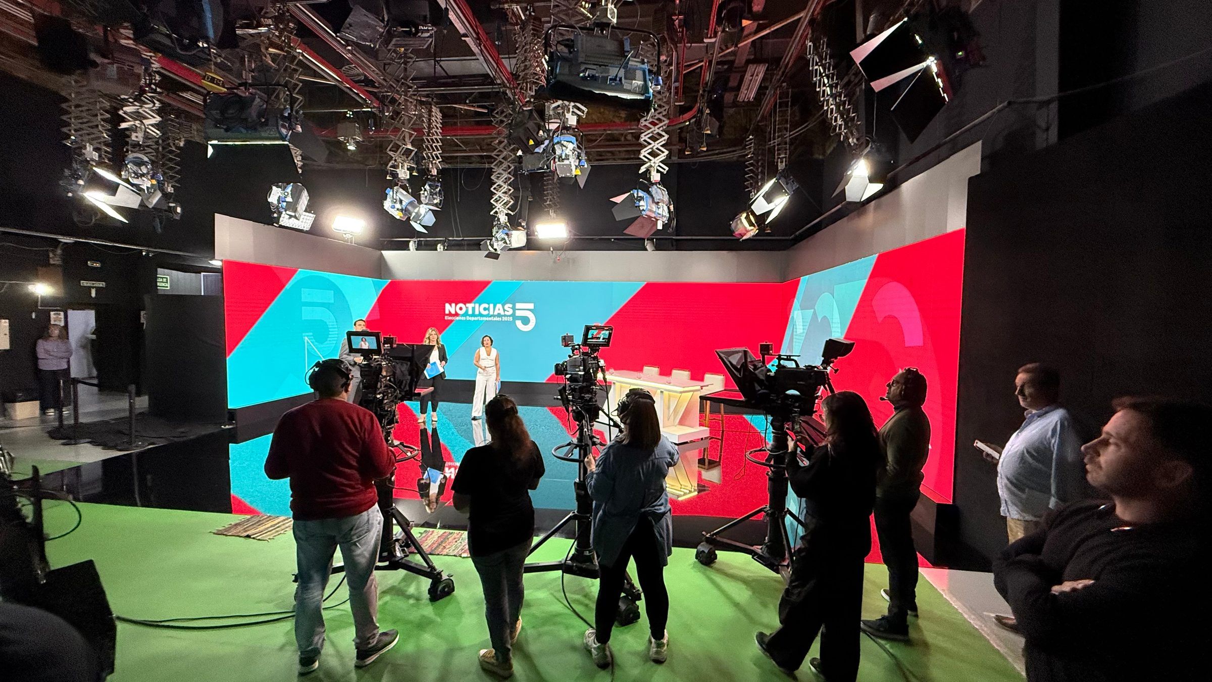 Equipo técnico y de piso trabajando en el estudio de Noticias 5 durante la cobertura electoral.