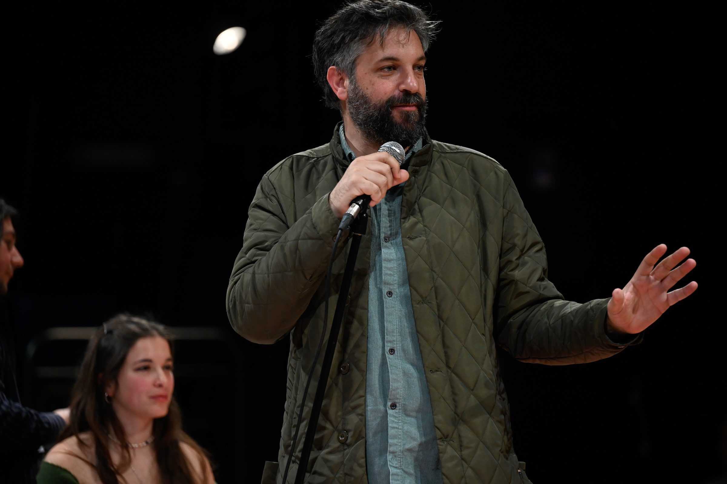 Oradora con micrófono en el escenario circular de Macondo en el Teatro Solís, con el público alrededor