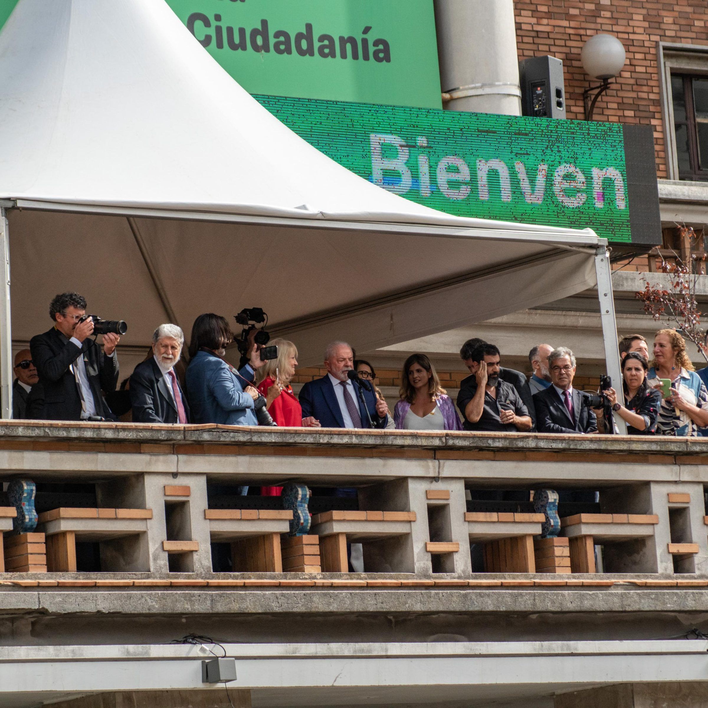 Balcón de la Intendencia de Montevideo con las autoridades e invitados frente a la explanada, bajo el cartel de bienvenida.