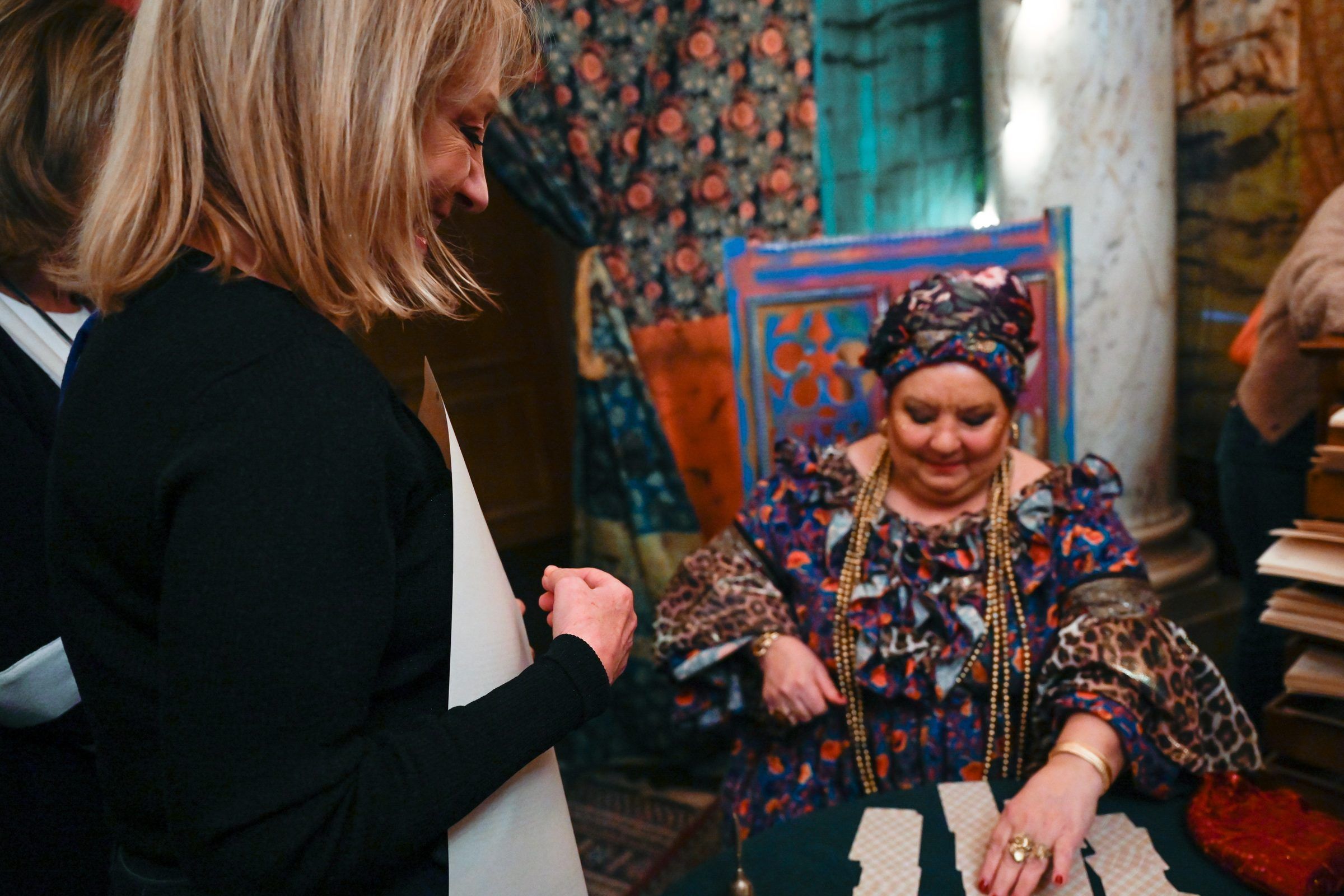 Intérprete con turbante y cartas sobre una mesa en el hall del Teatro Solís durante Macondo