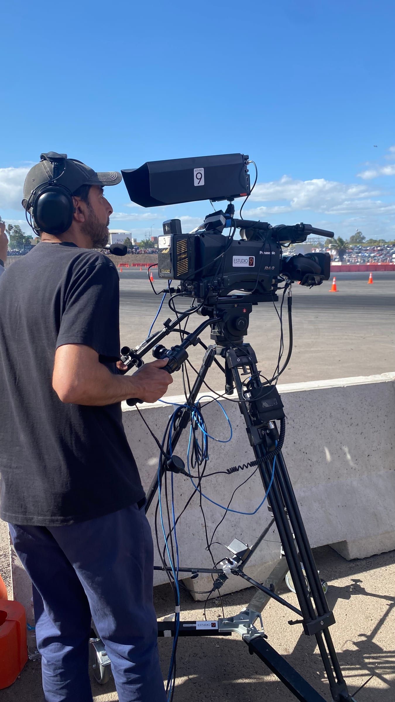 Camarógrafo con auriculares operando una cámara sobre trípode junto a la pista del Drift Park Solidario