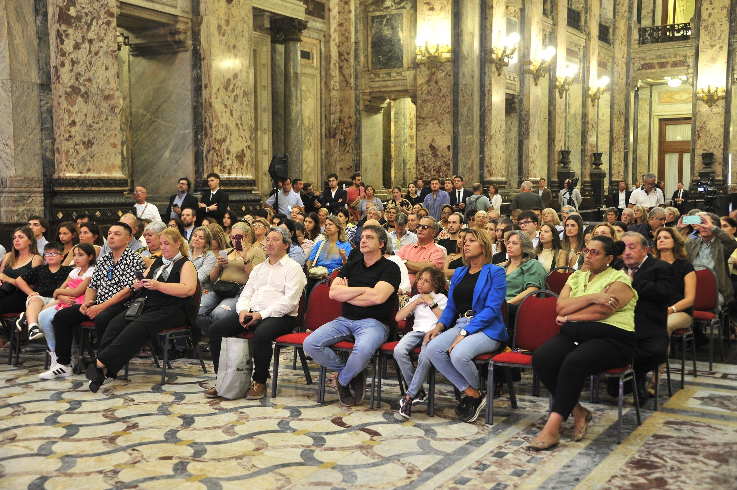 Público sentado en el hall del Palacio Legislativo siguiendo la sesión de la Asamblea General.