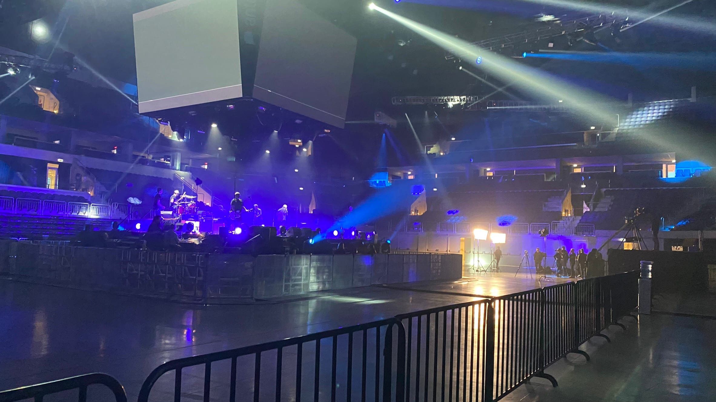 Escenario del Antel Arena con luces azules y dos pantallas cúbicas colgadas del techo, antes del concierto de Buitres